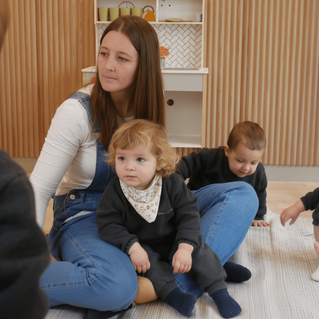 Educadora acompañando a un bebé en la bienvenida